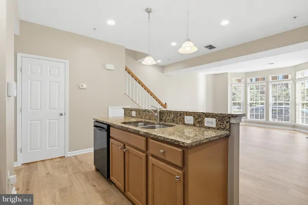 a hallway with granite countertop kitchen island a sink and a large window