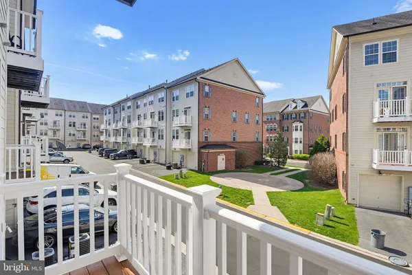 a front view of a building with lot of cars and trees