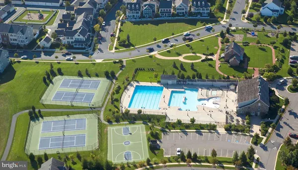 an aerial view of residential houses with outdoor space and trees