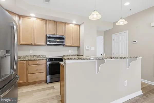 a kitchen with stainless steel appliances granite countertop a stove a sink and a refrigerator