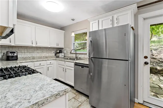a kitchen with a refrigerator a stove a sink and a window