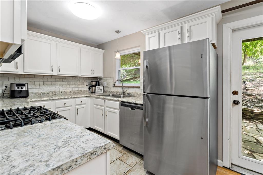 231 Woodside Road Pittsburgh, PA 15221 - Photo 11 of 34 a kitchen with a refrigerator a stove a sink and a window
