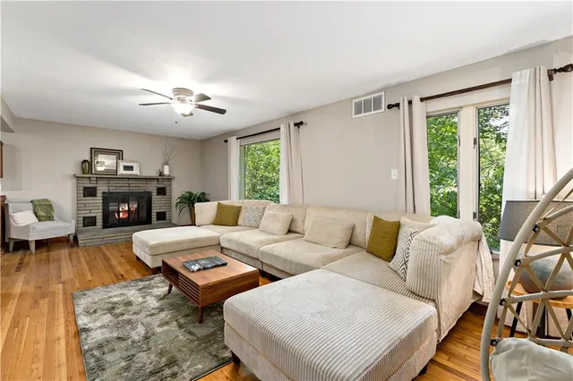 a living room with furniture fireplace and a large window
