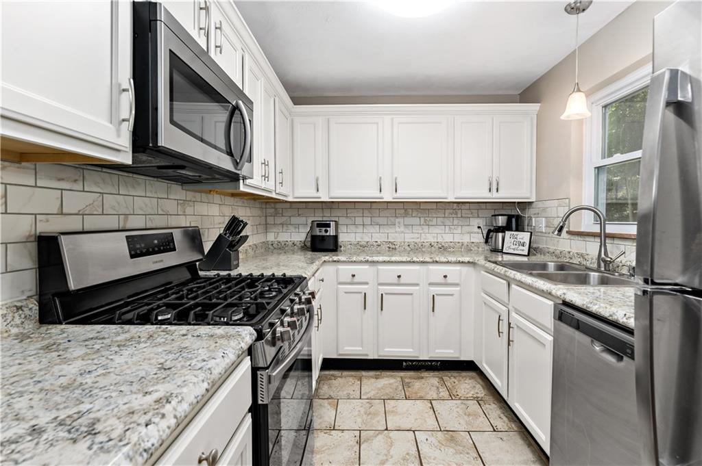 231 Woodside Road Pittsburgh, PA 15221 - Photo 9 of 34 a kitchen with stainless steel appliances granite countertop a stove a sink and a microwave