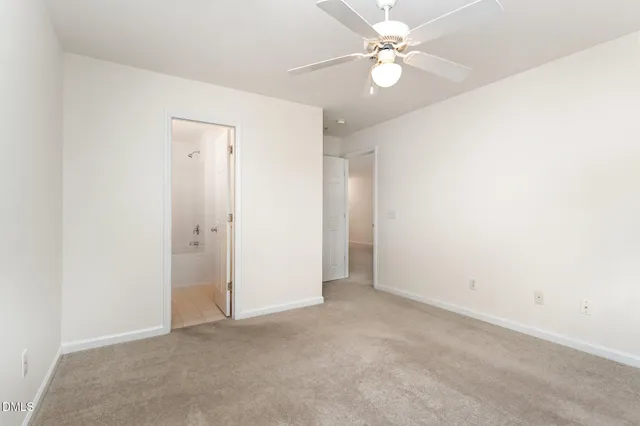 an empty room with a ceiling fan and a fan