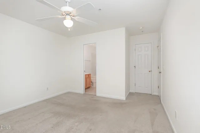 an empty room with a ceiling fan and a window