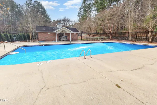 a view of yard with swimming pool and seating space