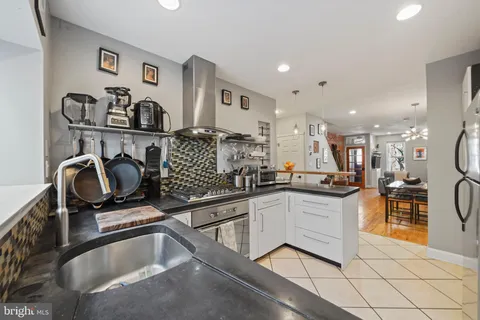 a kitchen with white cabinets a sink and appliances