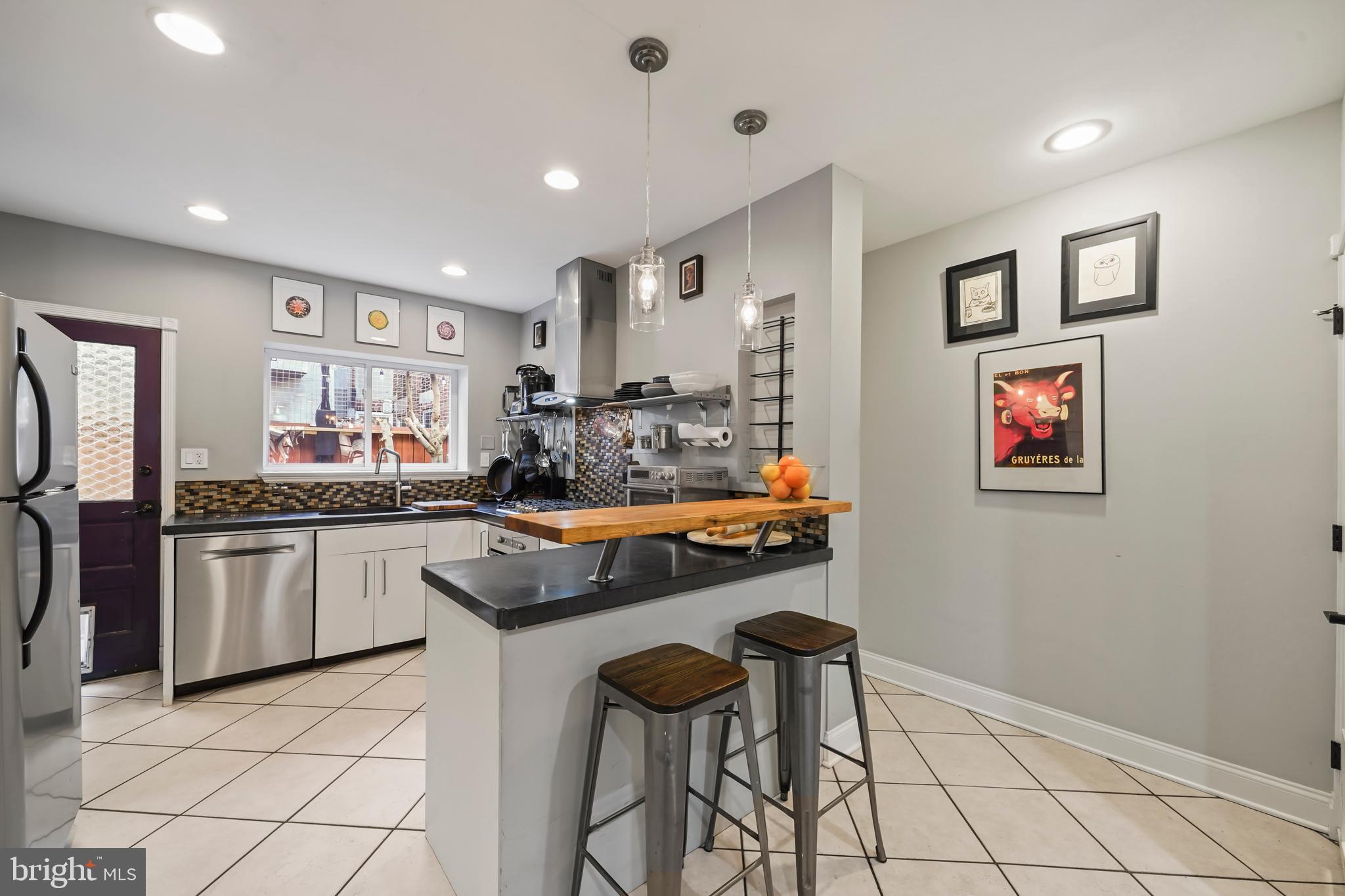 1318 South Alder Street Philadelphia, PA 19147 - Photo 18 of 39 a kitchen with stainless steel appliances granite countertop a stove a sink and a refrigerator
