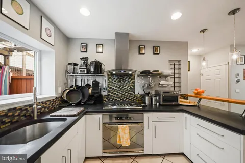 a kitchen with stainless steel appliances granite countertop a sink stove and cabinets