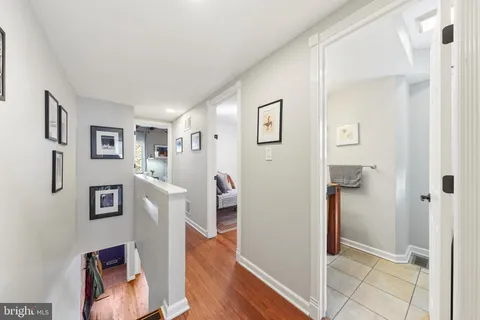 a view of a hallway with wooden floor and a living room