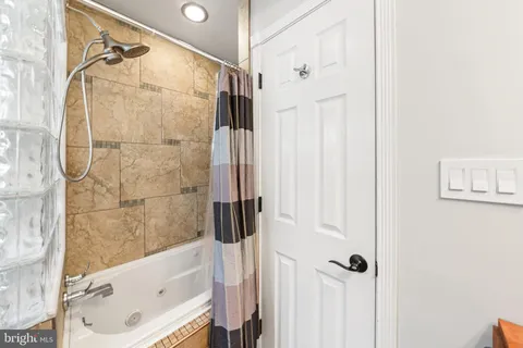a bathroom with a tub a sink and a shower
