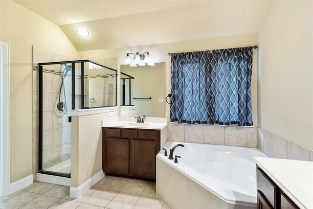 a bathroom with a tub a sink and a mirror