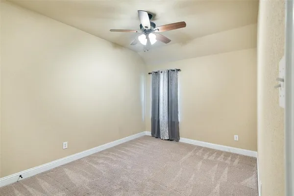 an empty room with a ceiling fan and a window