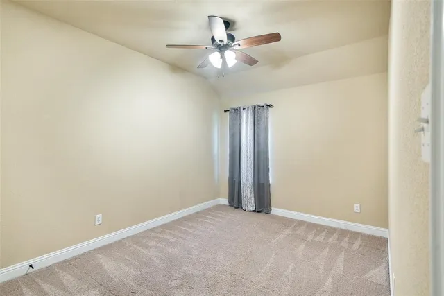 an empty room with a ceiling fan and a window