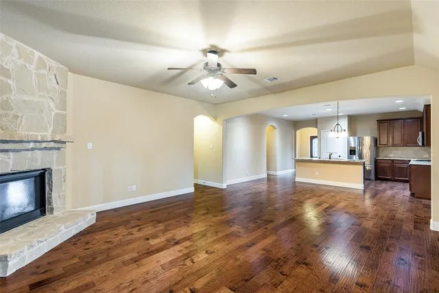 a view of an empty room with a fireplace and window