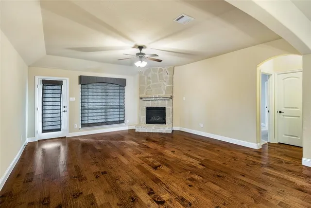 a view of an empty room with a fireplace and a window