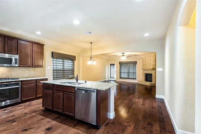 a large kitchen with stainless steel appliances granite countertop a stove and a sink