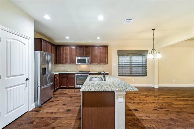 a kitchen with stainless steel appliances granite countertop a sink stove and refrigerator