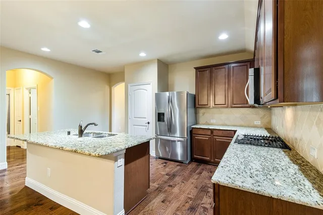 a kitchen with stainless steel appliances granite countertop a sink stove and refrigerator