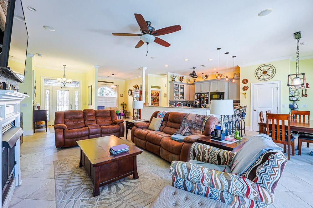 232 Waterfall Circle Little River, SC 29566 - Photo 9 of 40 Living room with ornamental molding, a fireplace, a chandelier, recessed lighting, and a ceiling fan