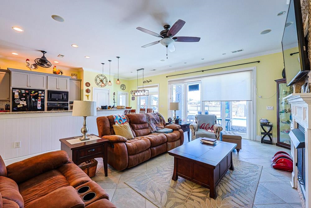 232 Waterfall Circle Little River, SC 29566 - Photo 10 of 40 Living area featuring crown molding, a ceiling fan, a fireplace, and recessed lighting