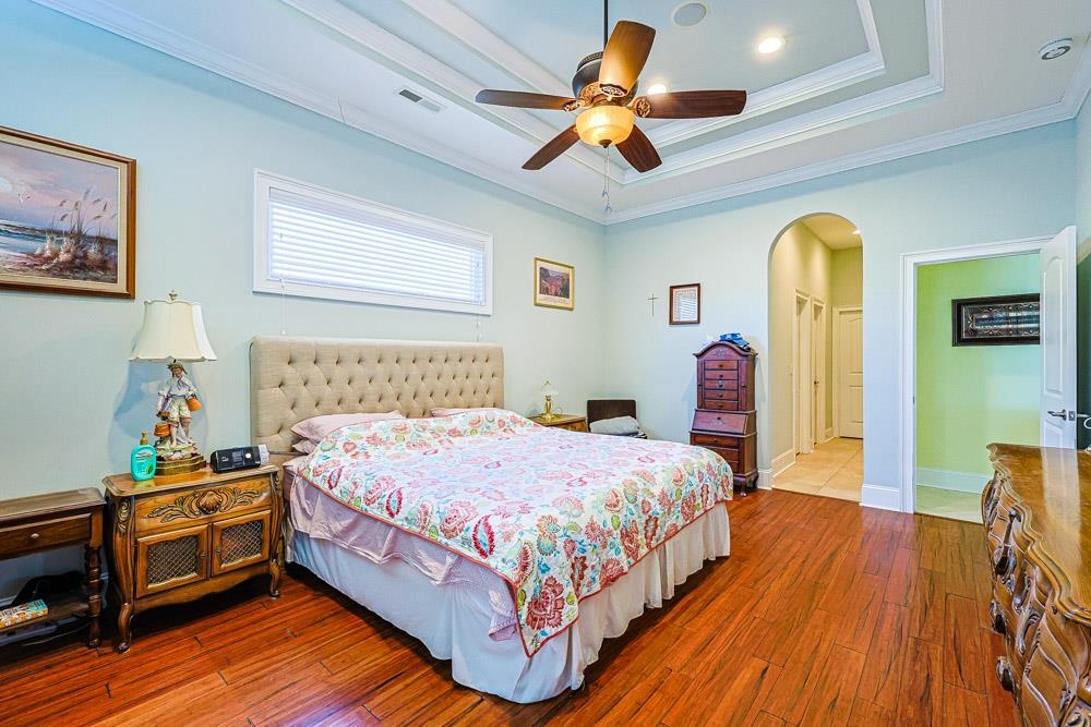 232 Waterfall Circle Little River, SC 29566 - Photo 14 of 40 Bedroom featuring dark wood-style floors, arched walkways, ceiling fan, and crown molding