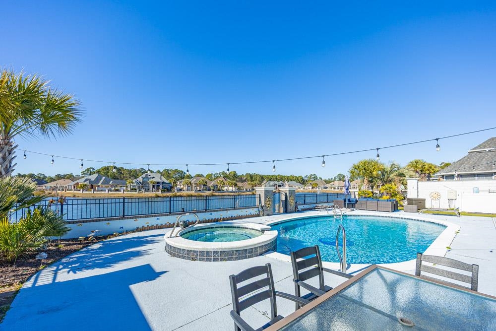 232 Waterfall Circle Little River, SC 29566 - Photo 2 of 40 View of pool featuring a pool with connected hot tub, a patio area, a residential view, a fenced backyard, and outdoor dining area