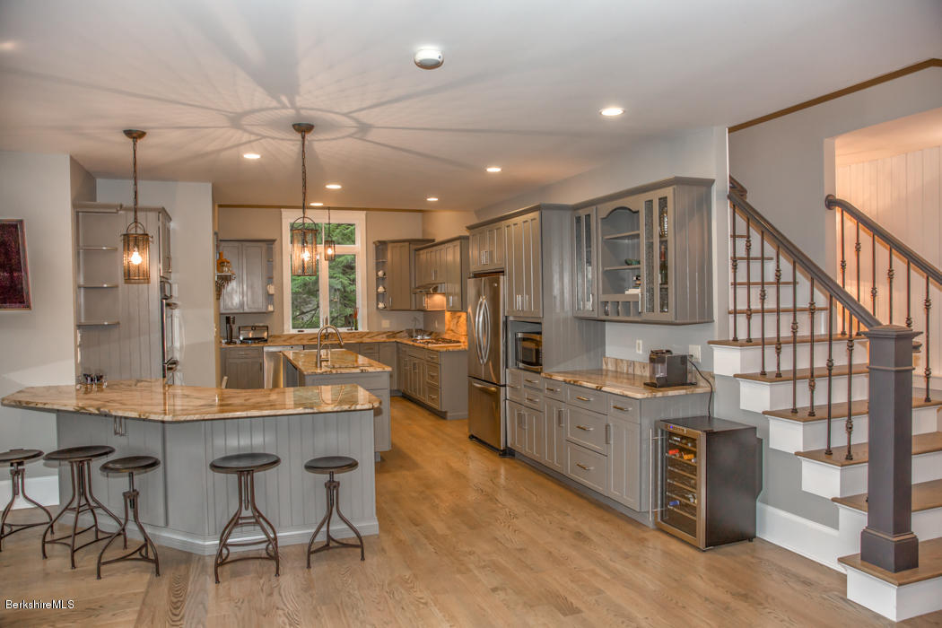 66 Mallard Road Otis, MA 01029 - Photo 10 of 26 a kitchen with stainless steel appliances kitchen island granite countertop a table chairs and a refrigerator