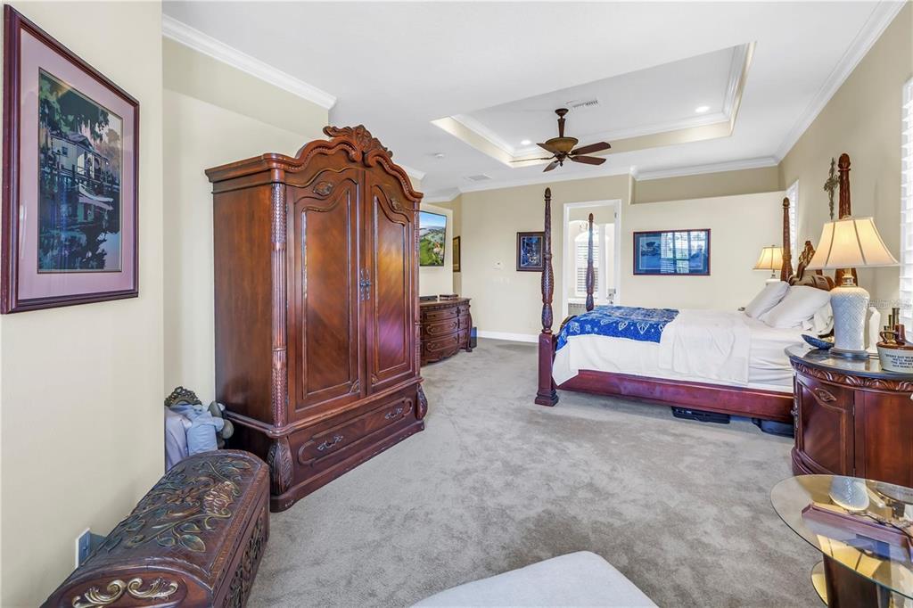 2101 North Pointe Alexis Drive, Unit 1 Tarpon Springs, FL 34689 - Photo 15 of 63 a bedroom with a bed and a chandelier