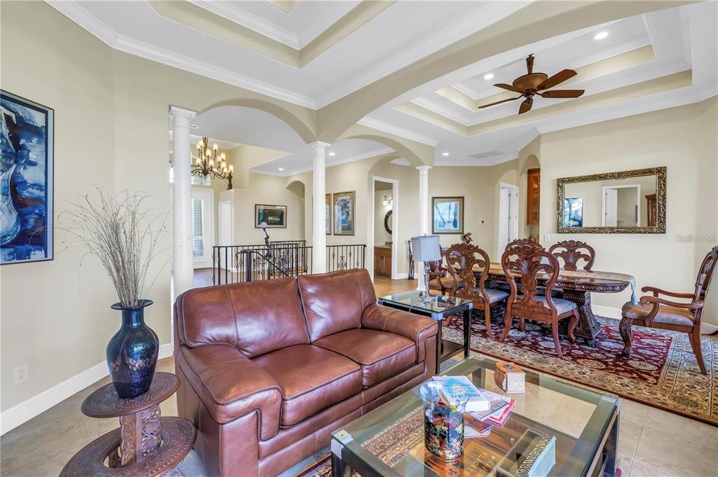 2101 North Pointe Alexis Drive, Unit 1 Tarpon Springs, FL 34689 - Photo 23 of 63 a living room with furniture a chandelier and a rug