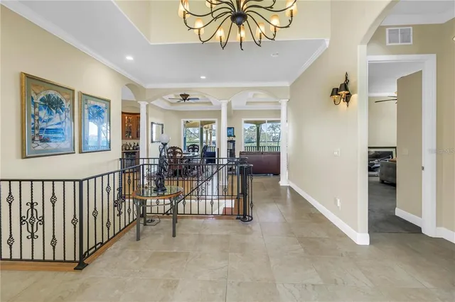 a spacious bedroom with a balcony a bed and a chandelier