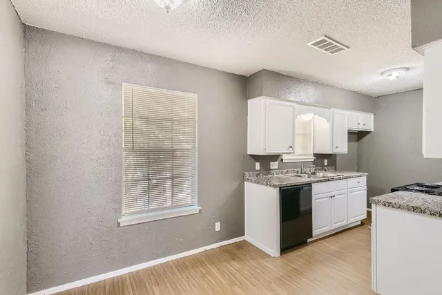 a kitchen with a stove and a wooden floors