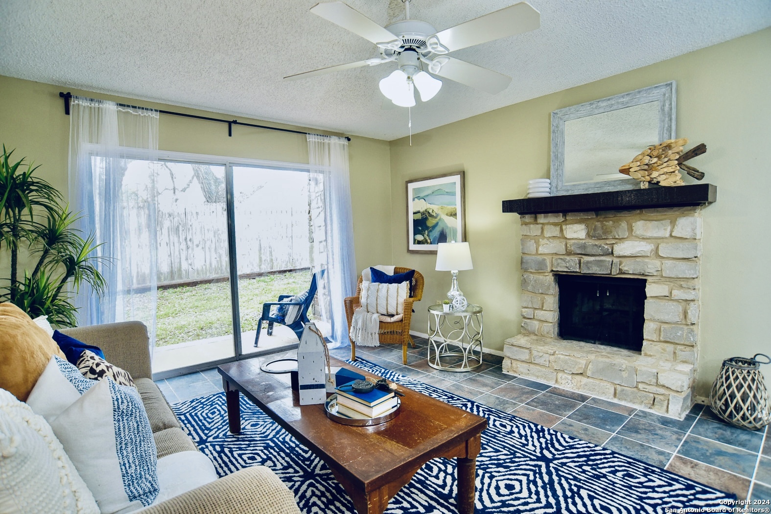 a living room with furniture a fireplace a rug and a window