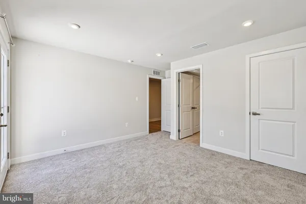 a large kitchen with stainless steel appliances a large counter top a sink and a refrigerator