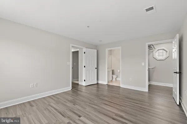 a view of an empty room with wooden floor