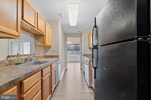 a kitchen with kitchen island a counter top space a sink and a refrigerator