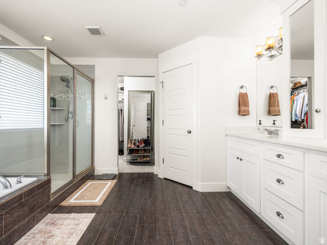 117 Ridge View Drive Elk Ridge, UT 84651 - Photo 21 of 42 Full bathroom with a walk in closet, vanity, a shower stall, dark wood finished floors, and a bath