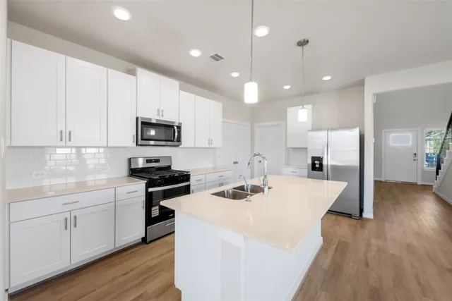 a kitchen with a sink stainless steel appliances and white cabinets
