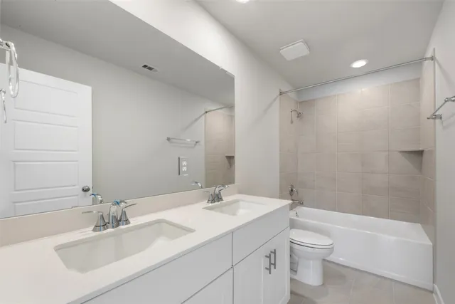 a bathroom with a bathtub shower sink vanity mirror and toilet