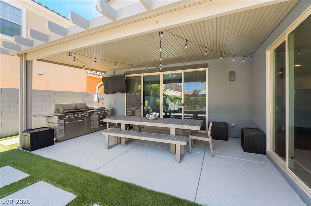 2166 Trivero Street Henderson, NV 89044 - Photo 33 of 61 An inviting outdoor patio features an integrated kitchen and sliding glass doors for seamless indoor-outdoor living.
