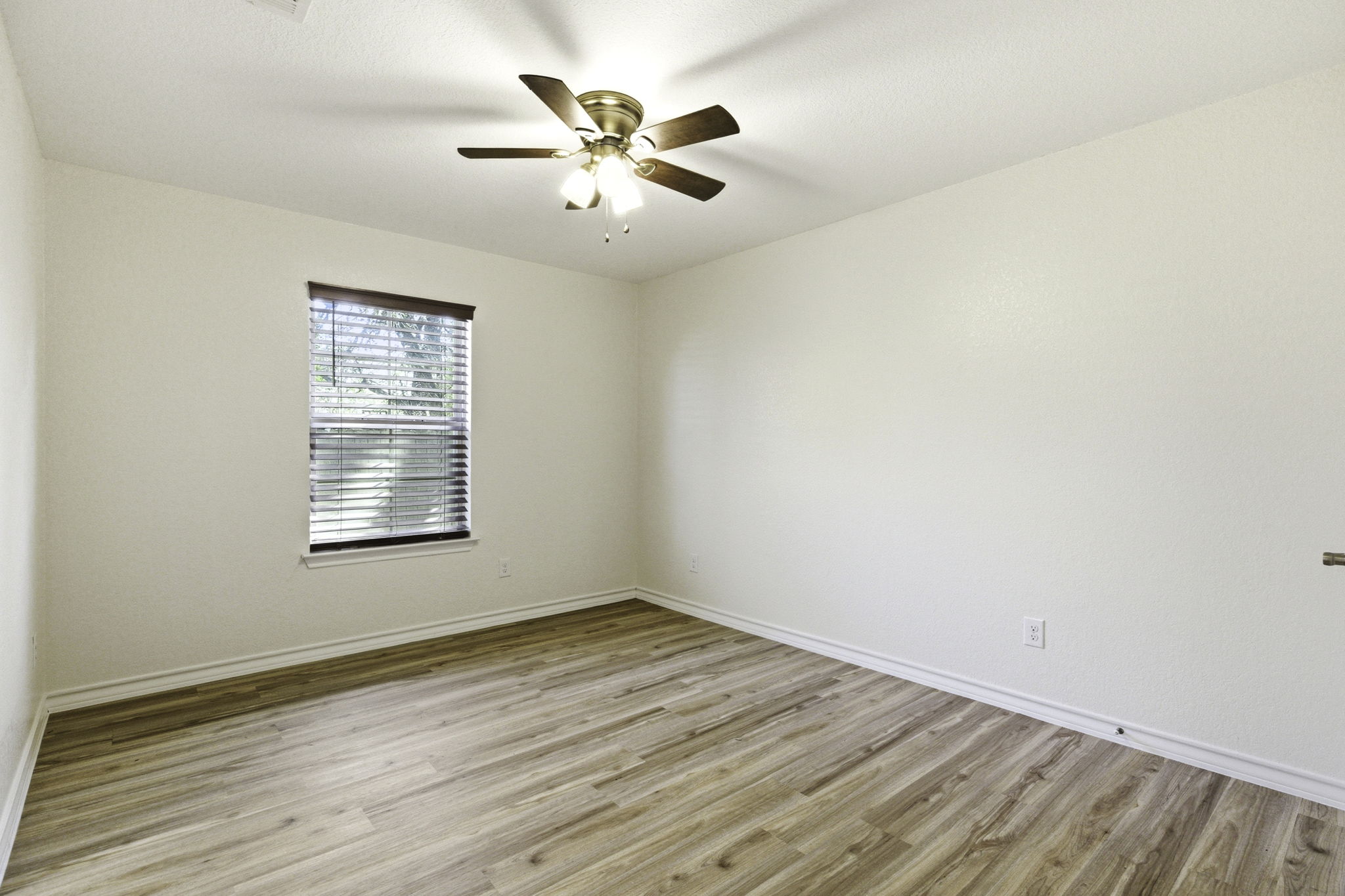 823 North Commerce Street, Unit A Lockhart, TX 78644 - Photo 19 of 28 an empty room with wooden floor and windows