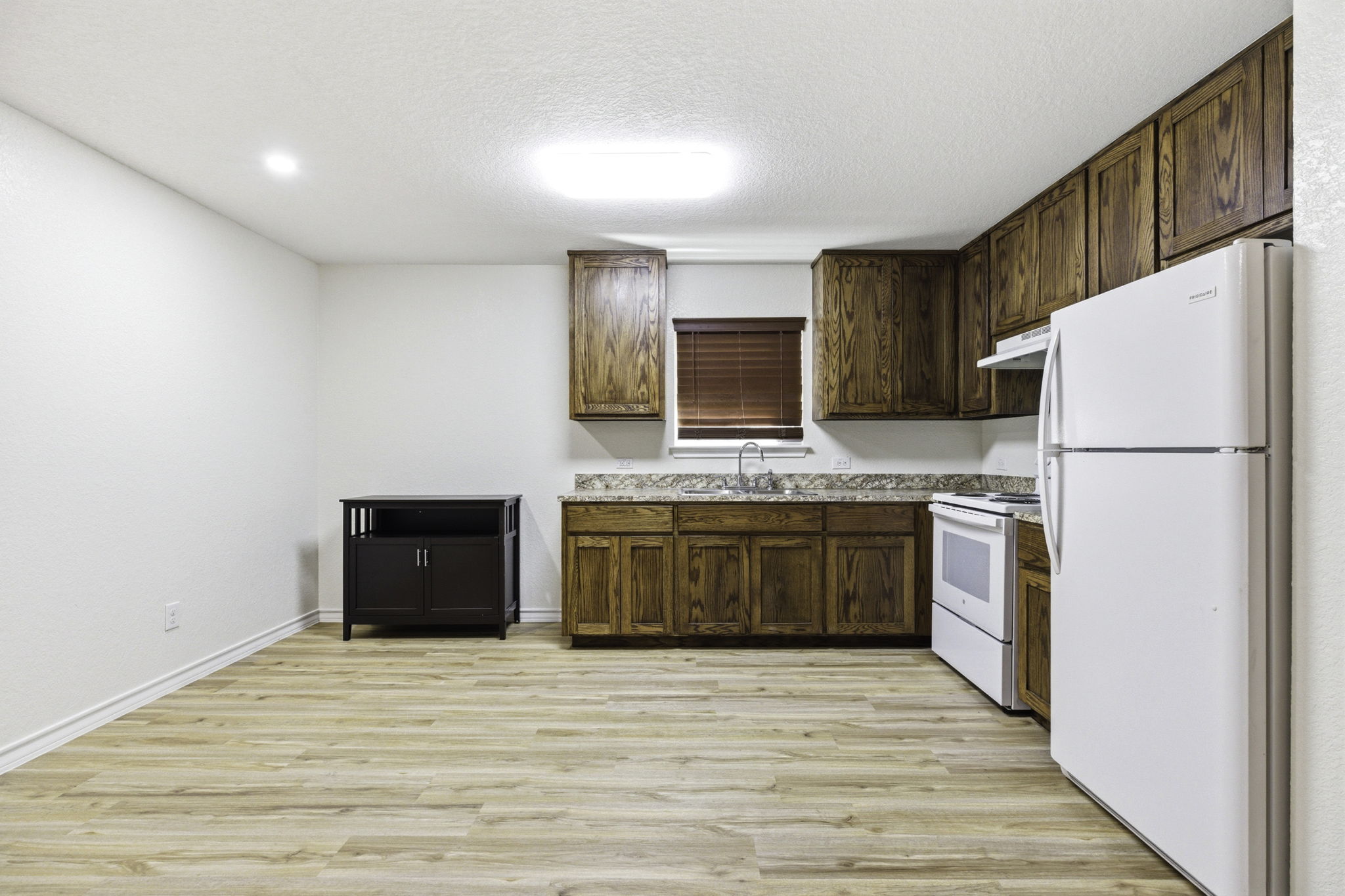 823 North Commerce Street, Unit A Lockhart, TX 78644 - Photo 10 of 28 a kitchen with a refrigerator and a stove top oven