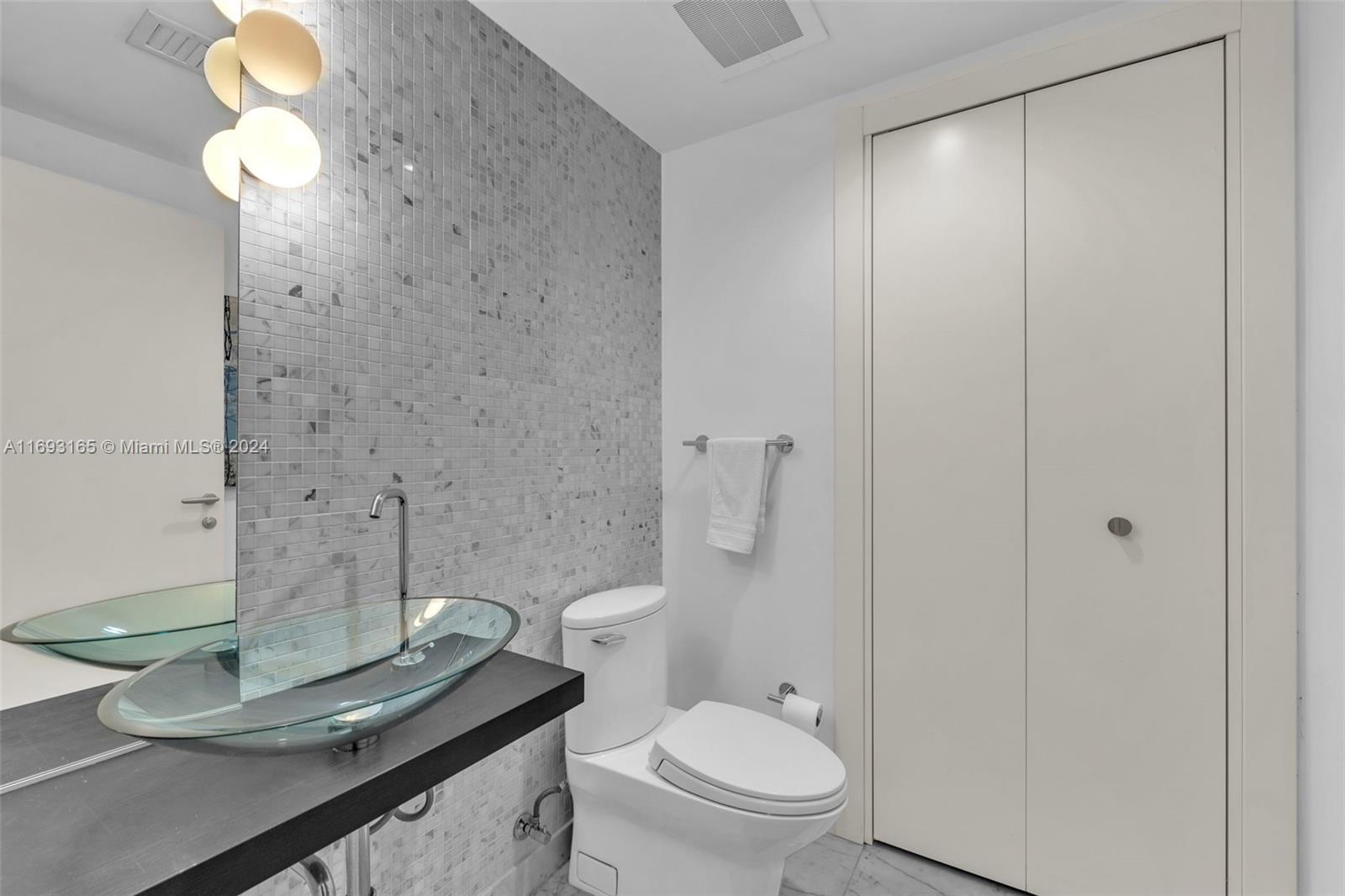 Downtown Miami Miami, FL 33131 - Photo 16 of 25 a bathroom with a granite countertop sink toilet and a mirror