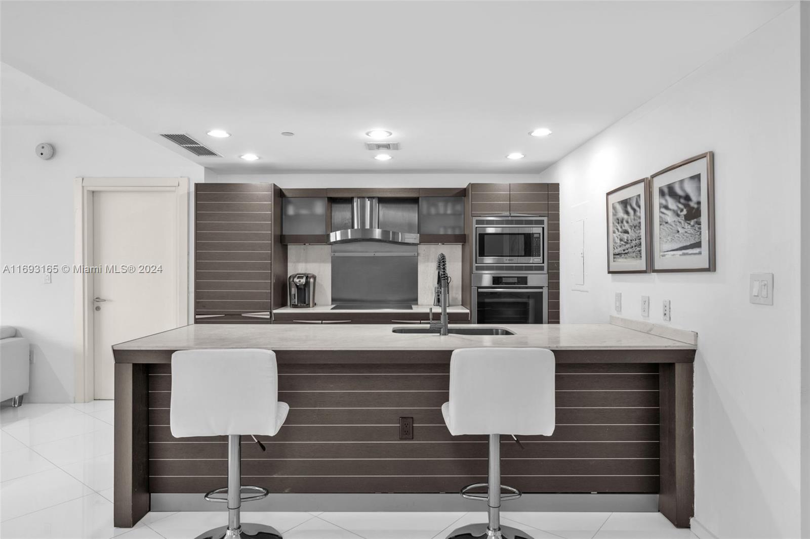 Downtown Miami Miami, FL 33131 - Photo 4 of 25 a kitchen with sink refrigerator and microwave