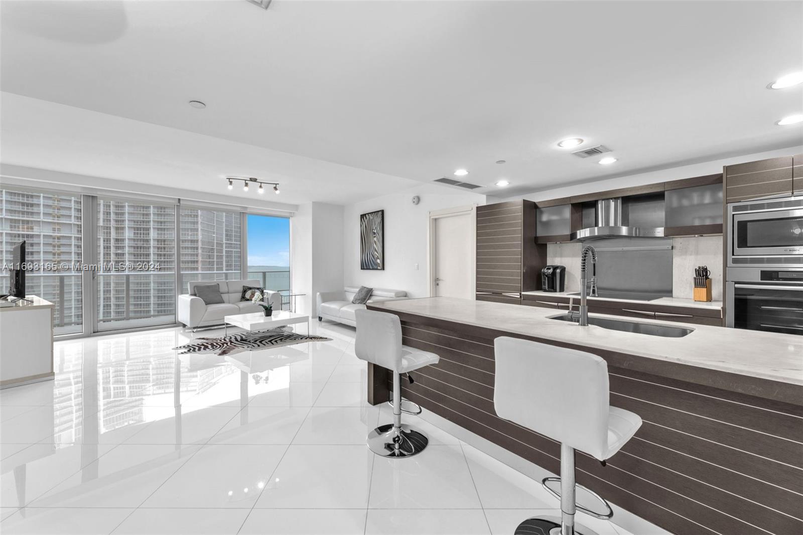 Downtown Miami Miami, FL 33131 - Photo 5 of 25 a living room with stainless steel appliances kitchen island granite countertop a sink and cabinets