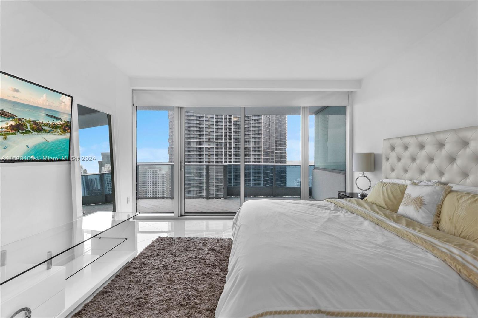 Downtown Miami Miami, FL 33131 - Photo 9 of 25 a bedroom with a large bed and glass door