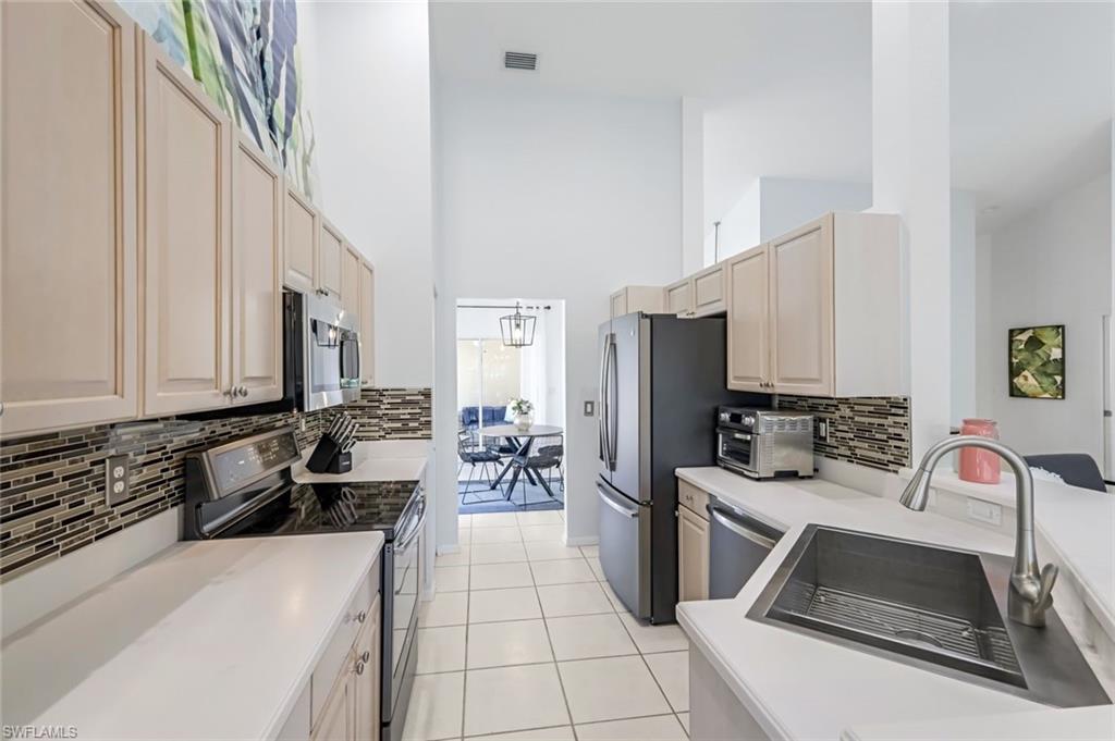 5360 Andover Drive, Unit 202 Naples, FL 34110 - Photo 11 of 25 a kitchen with a sink stove and cabinets