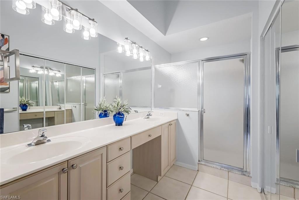 5360 Andover Drive, Unit 202 Naples, FL 34110 - Photo 16 of 25 a bathroom with a double vanity sink mirror and shower