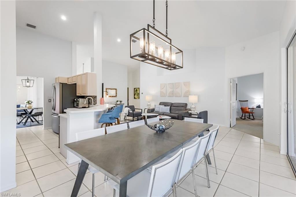 5360 Andover Drive, Unit 202 Naples, FL 34110 - Photo 8 of 25 a very nice looking open dining room with kitchen island a table and chairs in it